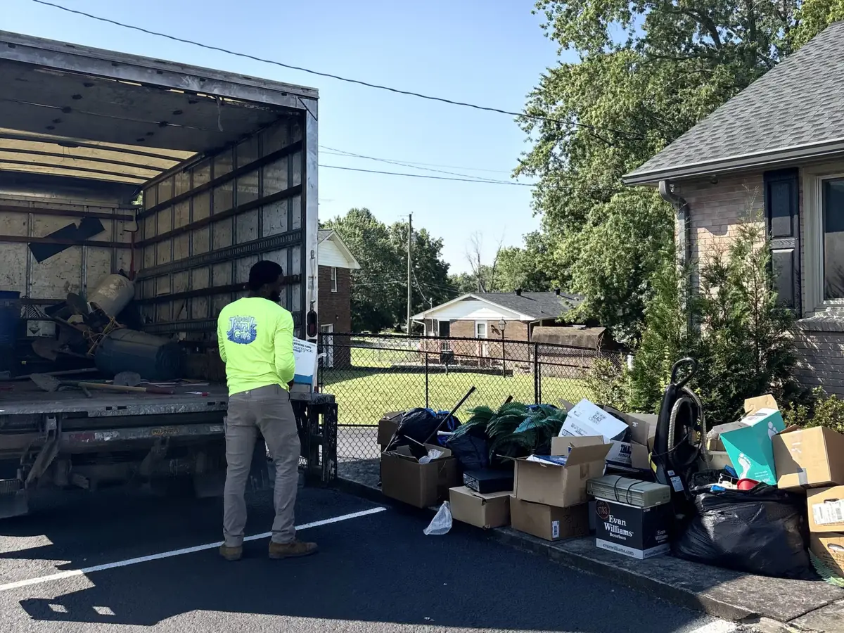 Local Junk Guys team member loading a sorted pile of junk into the truck for donation, recycling or disposal